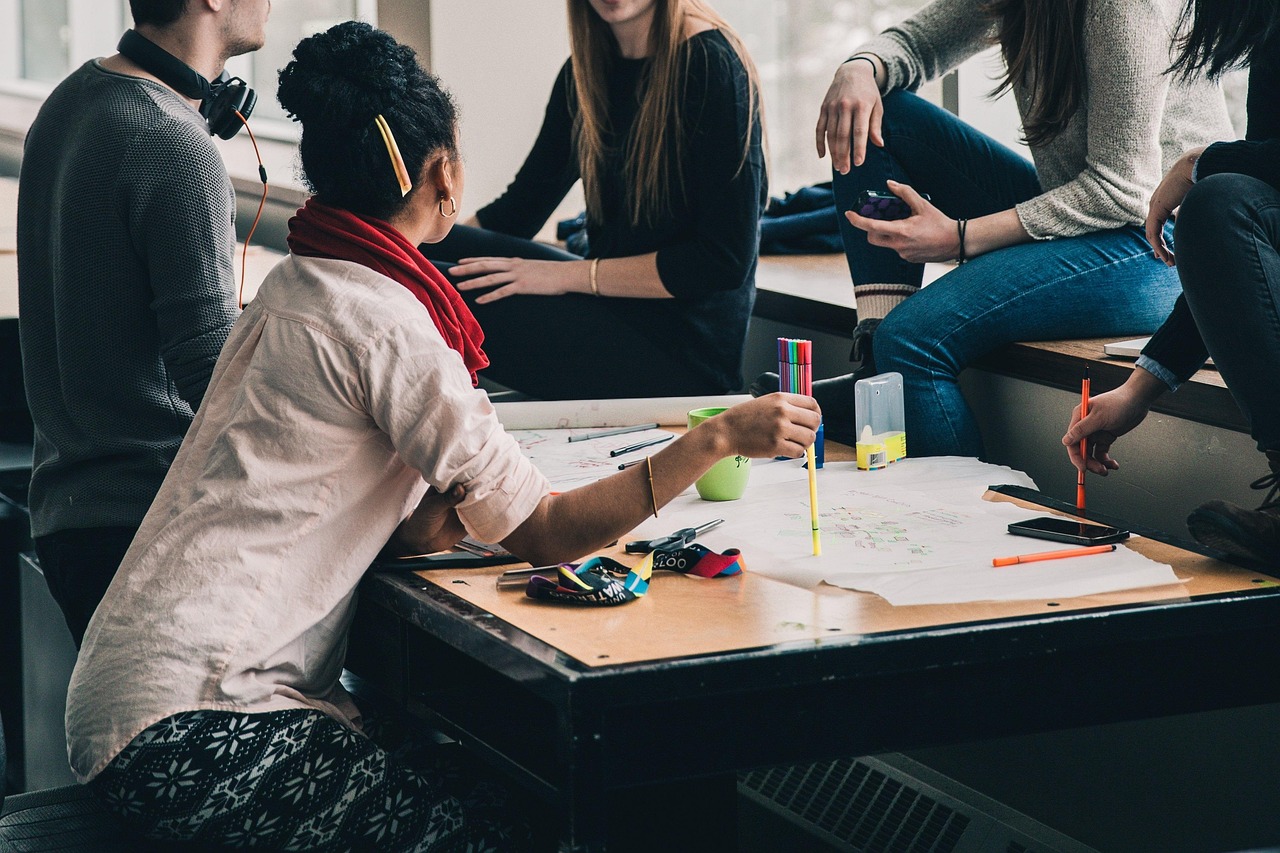 A group of students talking and working together around a table